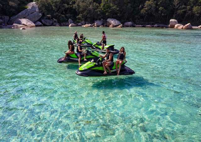  4 jet-skis, regroupant 7 personnes, arrêtés dans une crique à l'eau cristalline