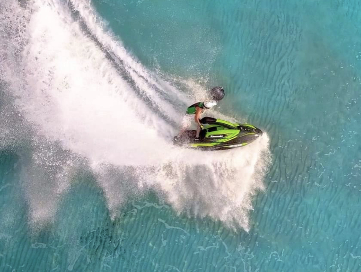  Homme faisant une manouvre en jet à bras à haute allure dans une mer turquoise