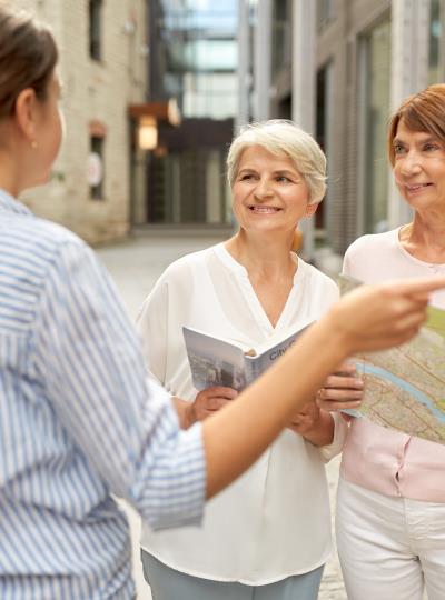 passerby showing direction to senior women in city