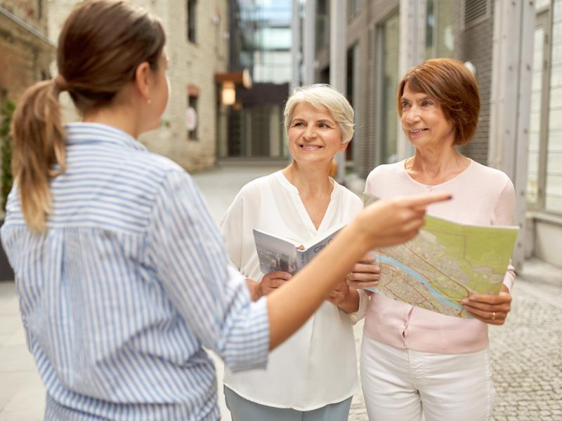 passerby showing direction to senior women in city